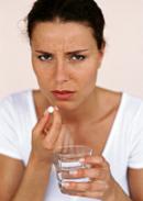 Frau mit Wasserglas und Tablette